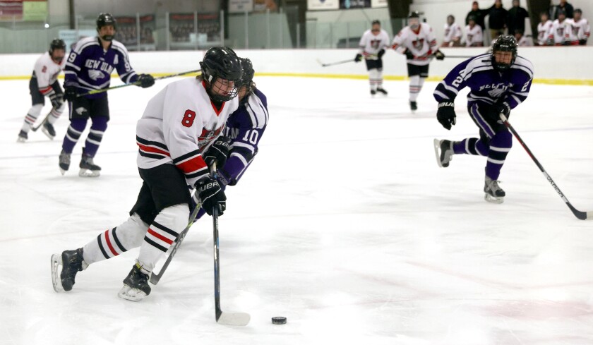 New Ulm defenders Jack Albrecht (9), Dawson Kraus (10) and Jace Schaefer (2) move to stop a fast break from Worthington Trojans Jonner Honius (8) during a Monday night game At the Worthington Ice Arena.