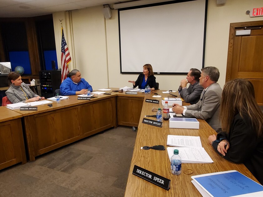 School Board members discuss around a table in the boardroom