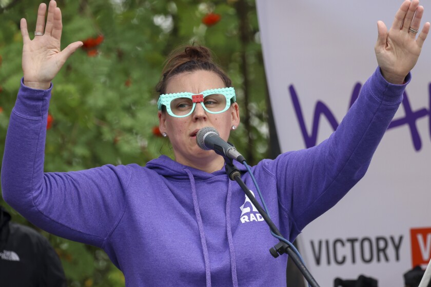 People in purple shirts celebrate recovery in outdoor park