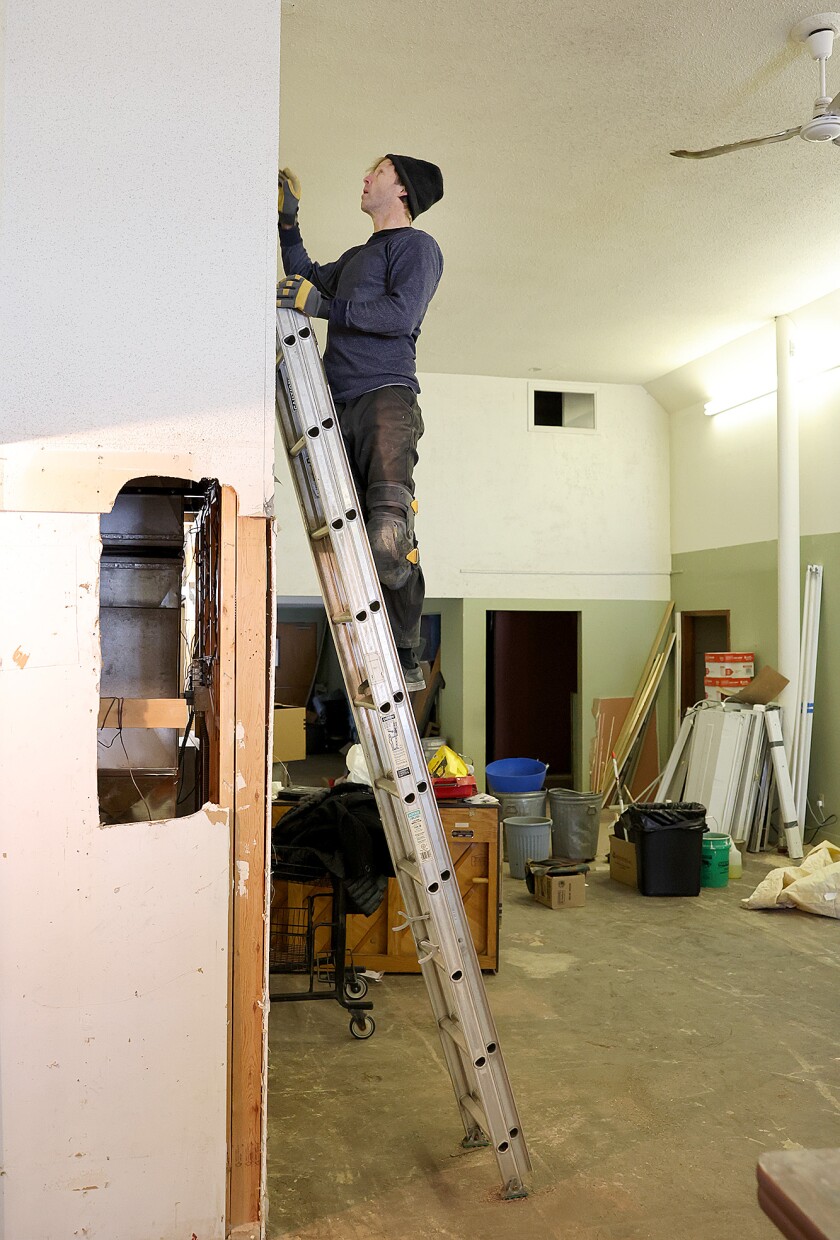 Man works on ladder.