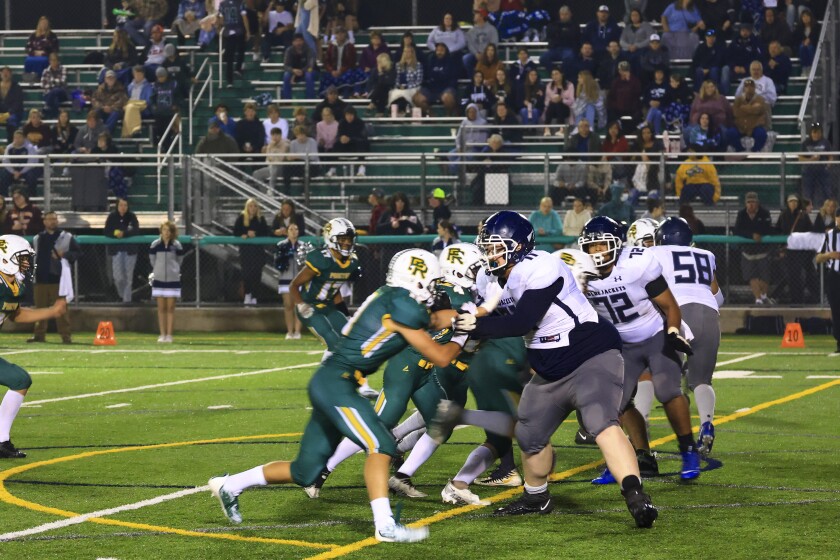 Football players and fans at outdoor high school game
