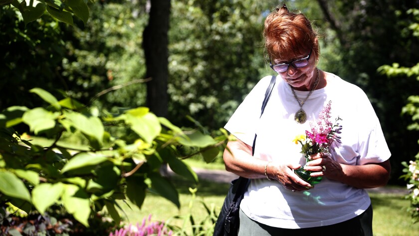 Woman holding flowers as she walks around the garden.
