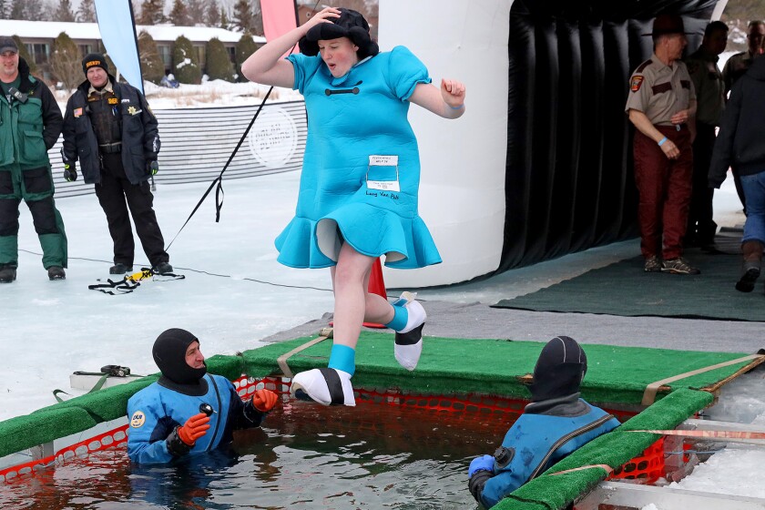 People jump into the water during the Polar Plunge event on Pelican Lake.