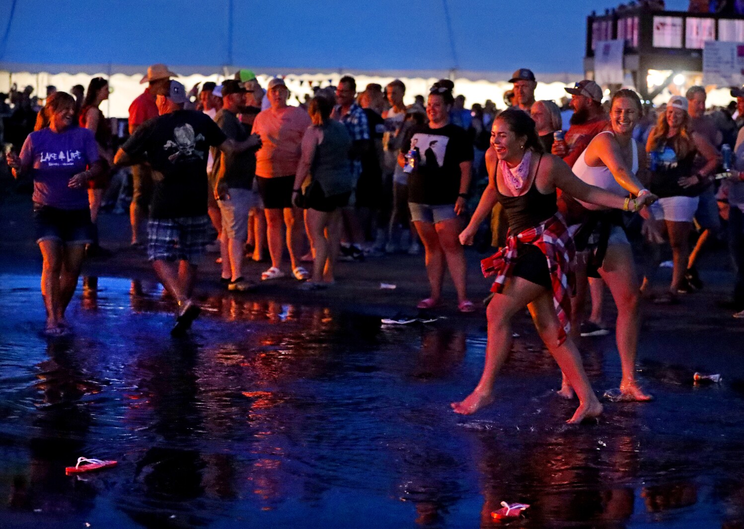 People at Lakes Jam dance in a puddle.