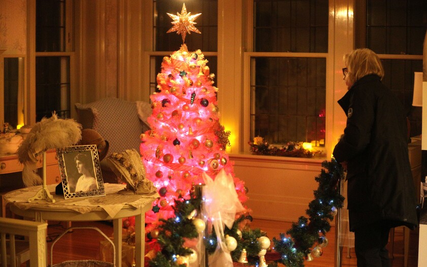 Woman looks at a pink Christmas tree at Glensheen