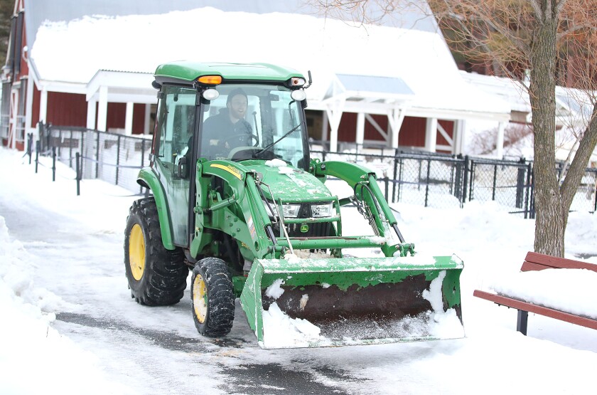 Forrest Michaels, director of facilities and grounds, clears snow near the barnyard at the Lake Superior Zoo