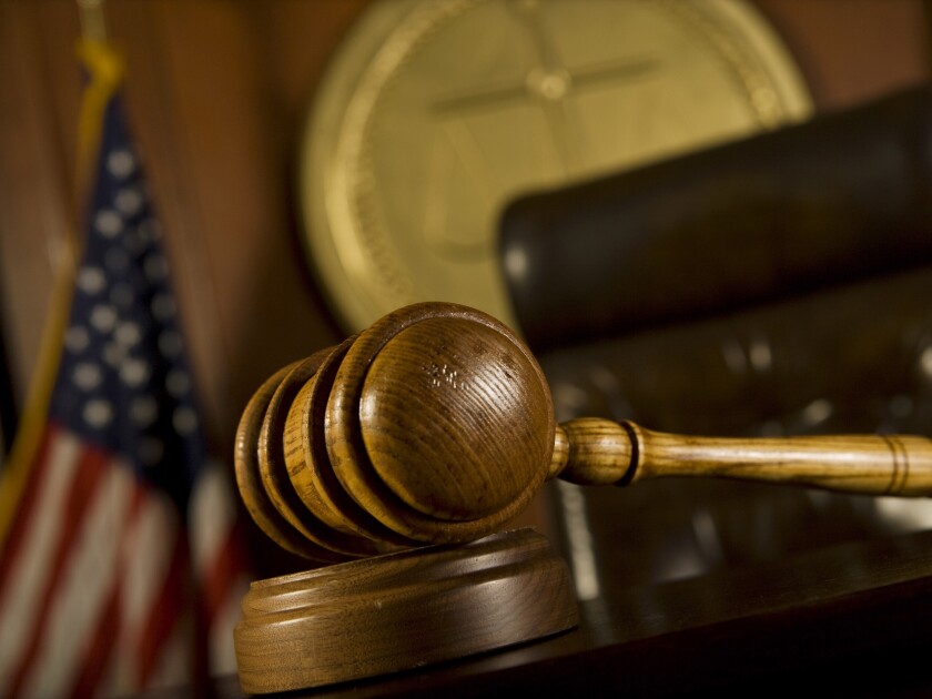 wood gavel with American flag in background