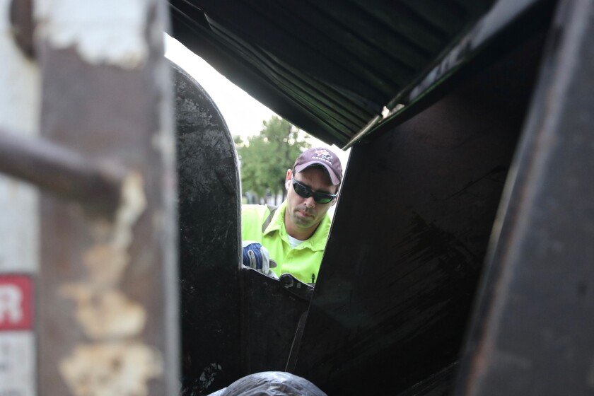 Patrick Peterson, sanitation worker for the City of Fargo, at work early Wednesday, July 7, 2021 nearby 13th Avenue Fargo.jpg