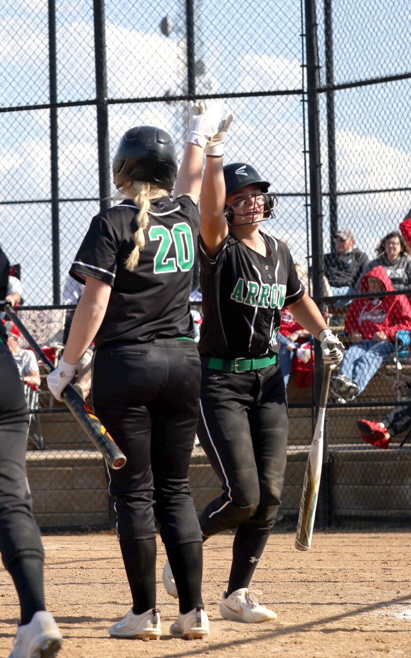 Pipestone Area Arrows Kayla Hubbling gets a high five from teammate Brynn Manzey (20) after scoring a run on Luverne Cardinals during Section 3AA softball championship Thursday in Marshall.