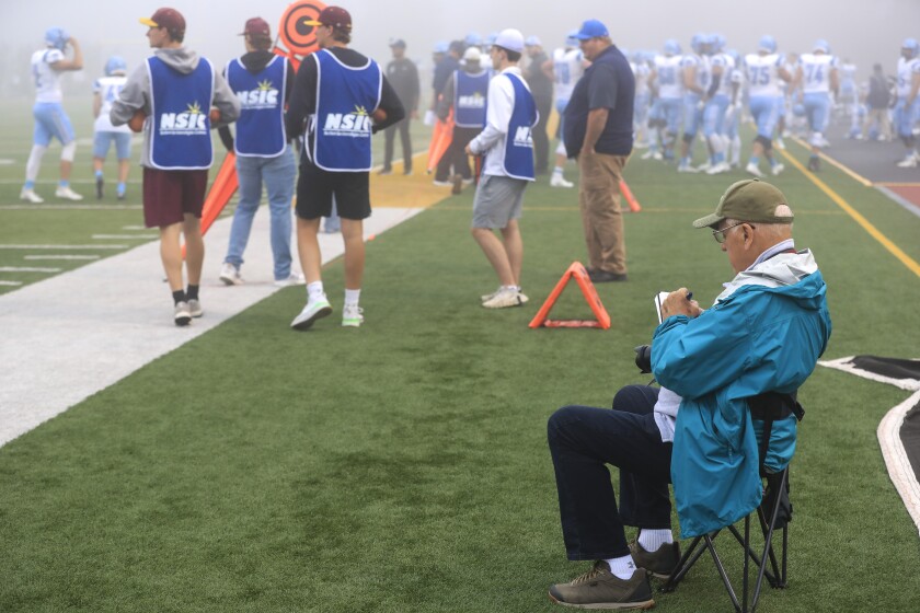 man writing notes on a pad of paper