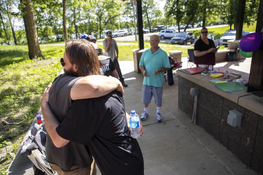 Gerald Cloutier Jr. is hugged by friend Emmit Bjork after Cloutier graduated from 8th Judicial District Drug Court at Robbins Island Regional Park on June 8, 2022.