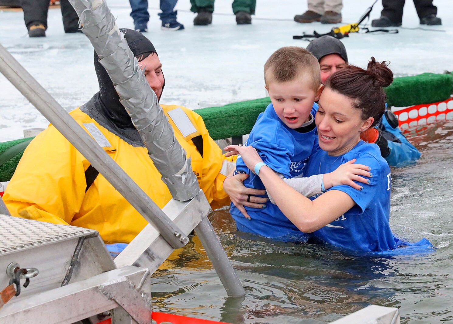 People jump into the water during the Polar Plunge event on Pelican Lake.