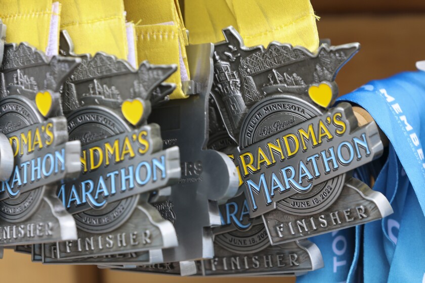 Athletes running and celebrating at the finish line area of Grandma's Marathon