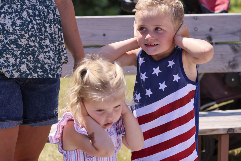 People wearing red white and blue patriotic themed clothing participating in outdoor parade