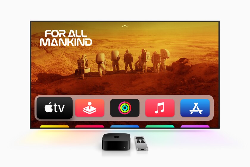 Apple TV dan remote control di depan gambar Apple TV di layar TV.