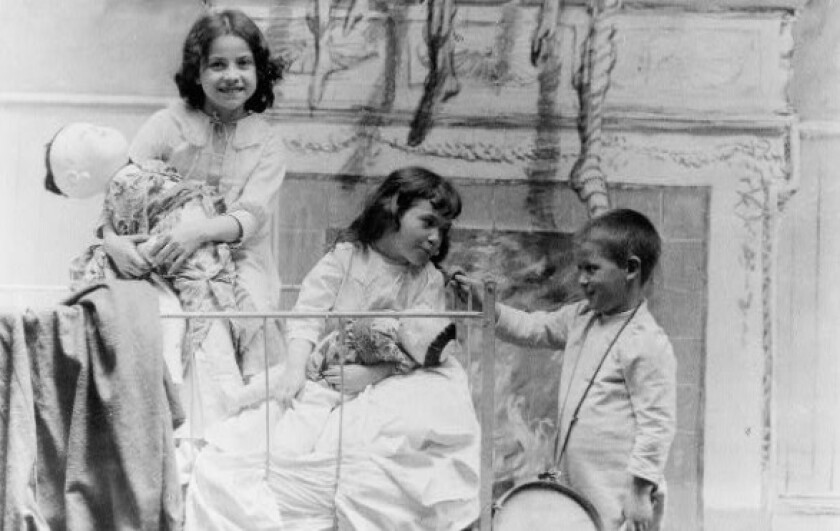Christmas morning in about 1900, with a mantle in background where Christmas stockings have been hung. Library of Congress.jpg