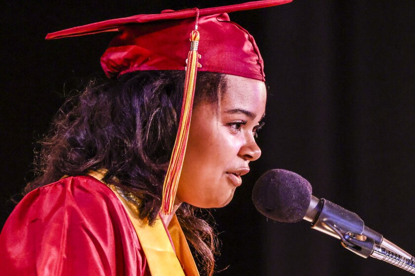 Students in maroon robes graduate
