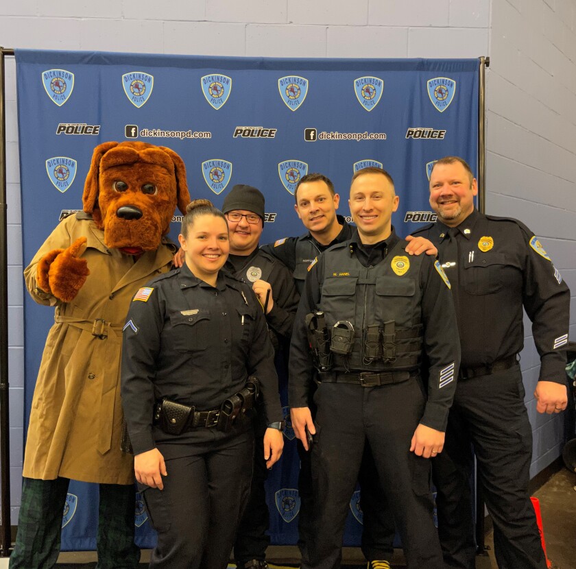 From left to right, McGruff the Crime Dog, Detective Senior Officer Tiffany Whinery, Senior Police and School Resource Officer Taylor Peters, Officer Chad Hopponen, Lt. Mike Hanel and Sgt. Jeremy Moser of the Dickinson Police Department pose for a photo op Saturday, March 12, 2022, during the 3rd Annual Skate with a Cop at the West River Ice Center.
