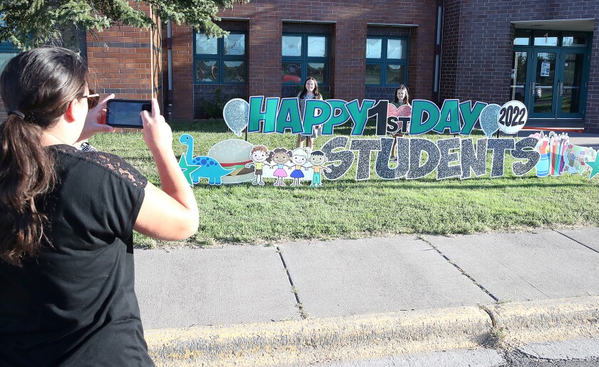 Elisa Herubin, left, takes first day of school photos of her daughters Macee Herubin, center, and Emma Herubin outside Great Lakes Elementary School