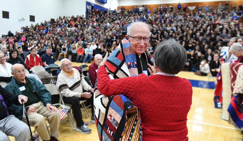 Korean war veteran Fred Ehrich recieves a quilt from Cheryl Bailey, of Quilts of Valor, as a token of gratitude for his service Friday, Nov. 9, at Brainerd High School's Veterans Day program. Steve Kohls / Brainerd Dispatch video and gallery
