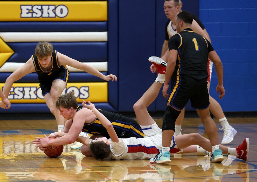 Players fight for loose ball on the ground.