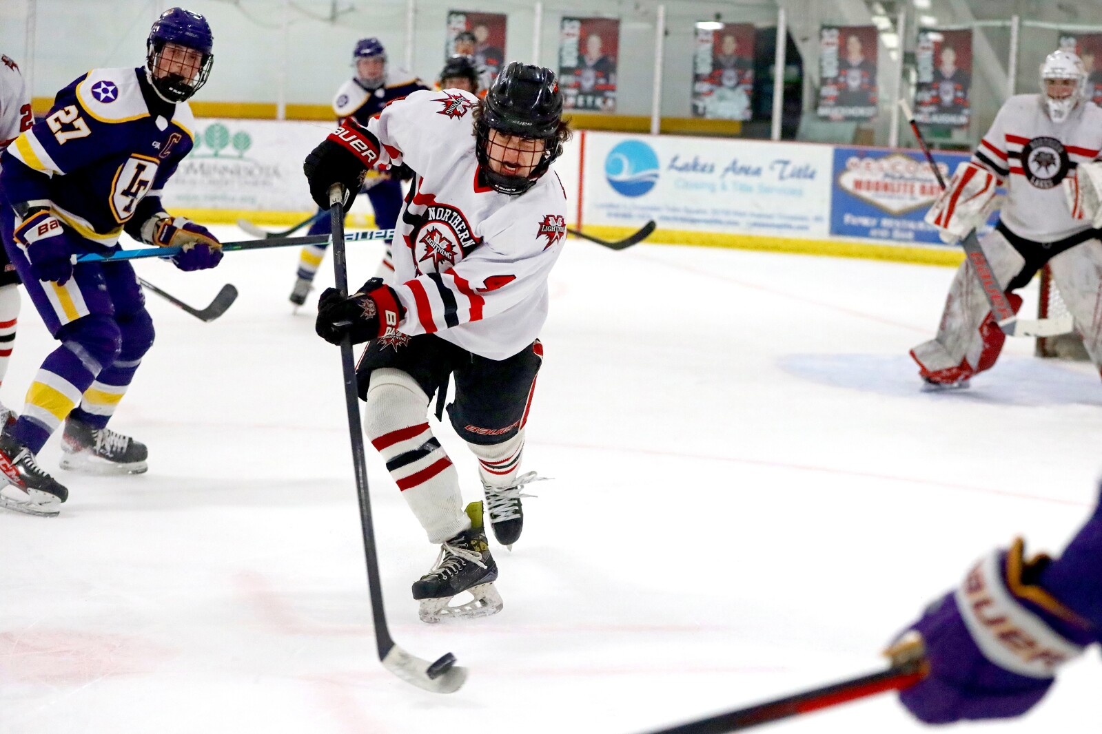 Northern Lakes' Cole Andersen hits the puck against Little Falls on Wednesday, Dec. 28, 2022, at Breezy Point Ice Arena.
