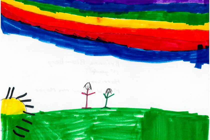 Two people standing on green grass under a rainbow.
