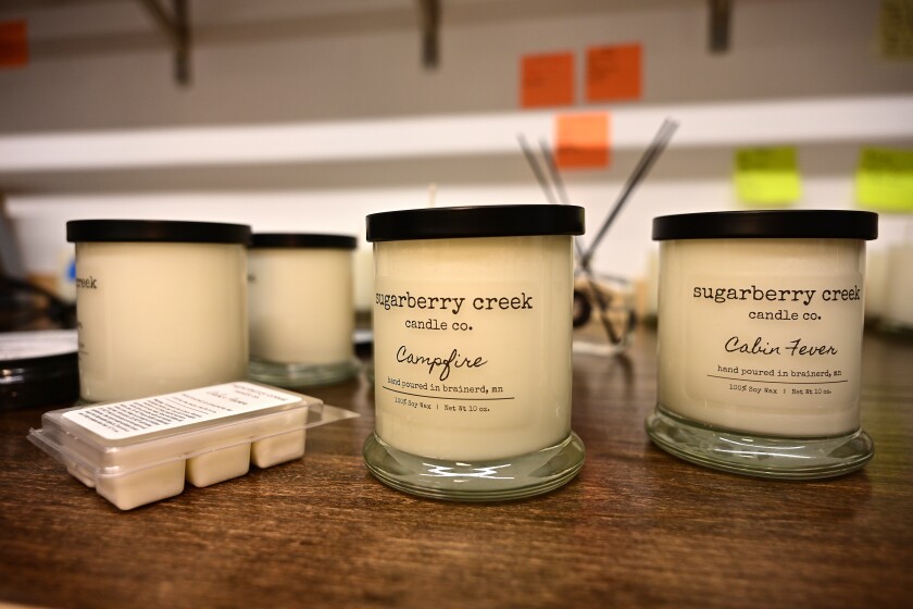 White jar candles sit on wooden table