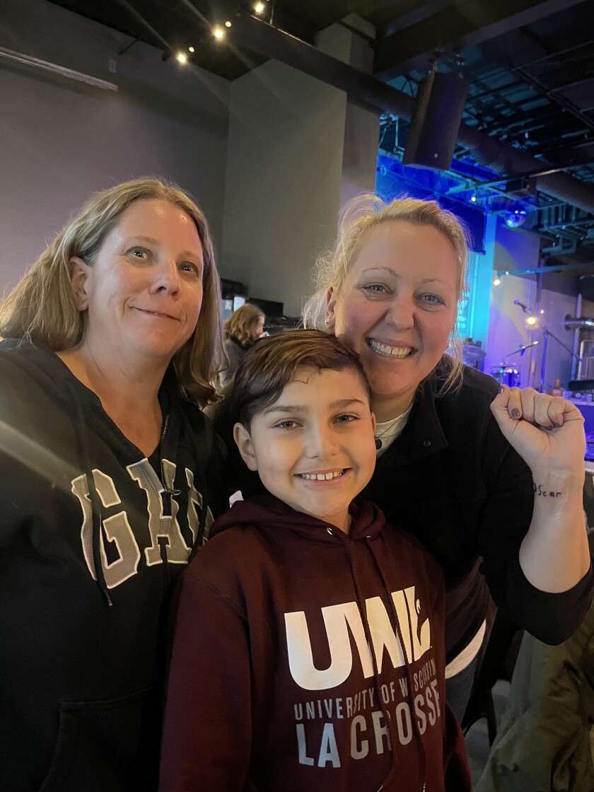 Julie Dahl with Krissy Luedtke and her son Oscar showing off the tattoo he designed..jpg