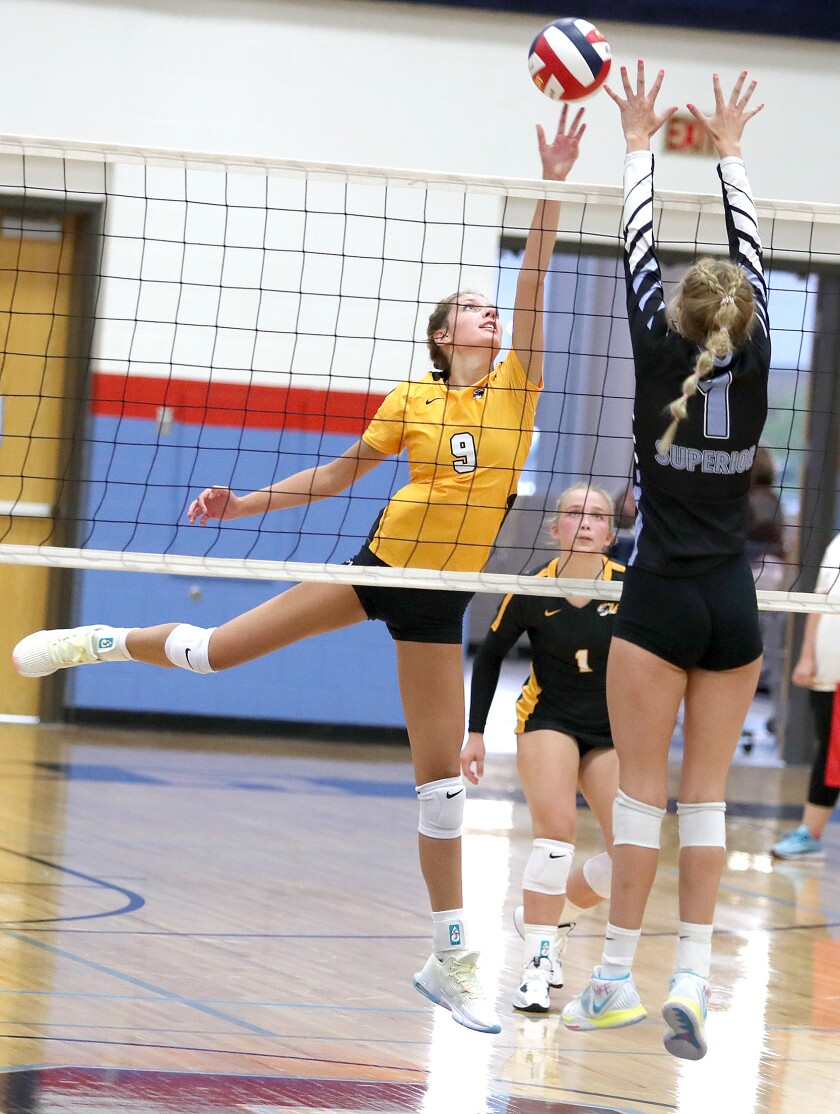 Northwestern’s Brynn Hessel (9) tips the ball over Superior’s Sophie Linden (1) during the match in Superior