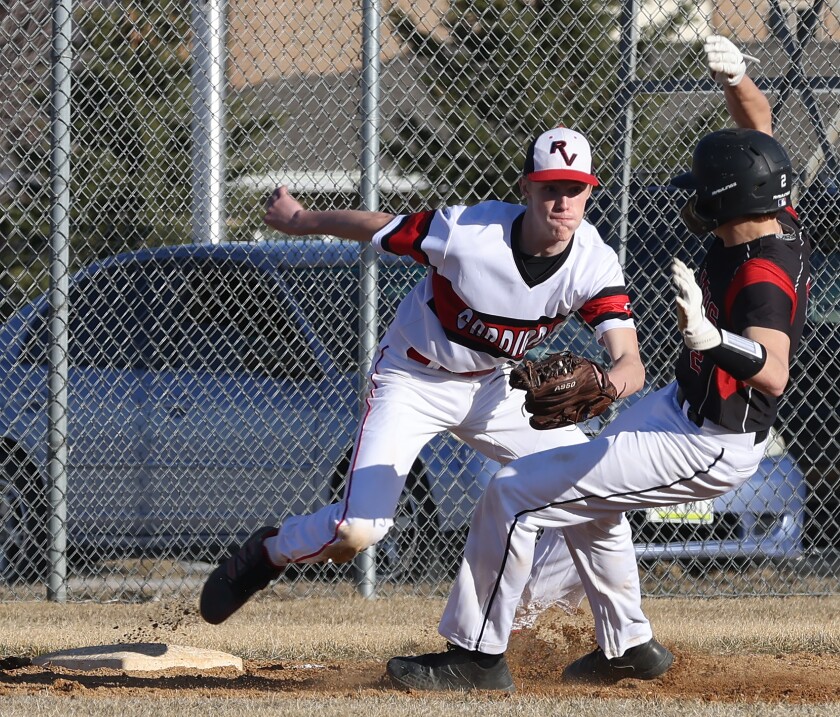 Trojans Jake Brandner attempts to steal third as Redwood Valley's Brandon Lang moves in to tag during a Monday evening game in Worthington.