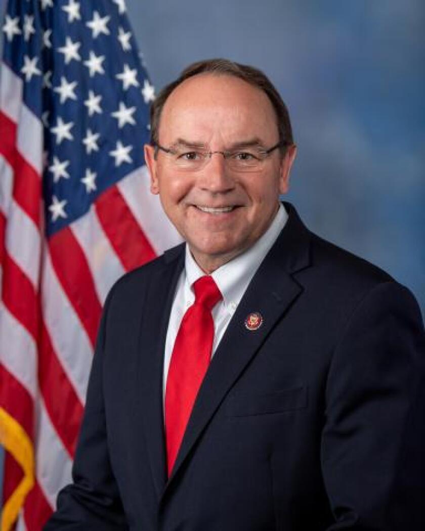 Man in suit in front of U.S. flag