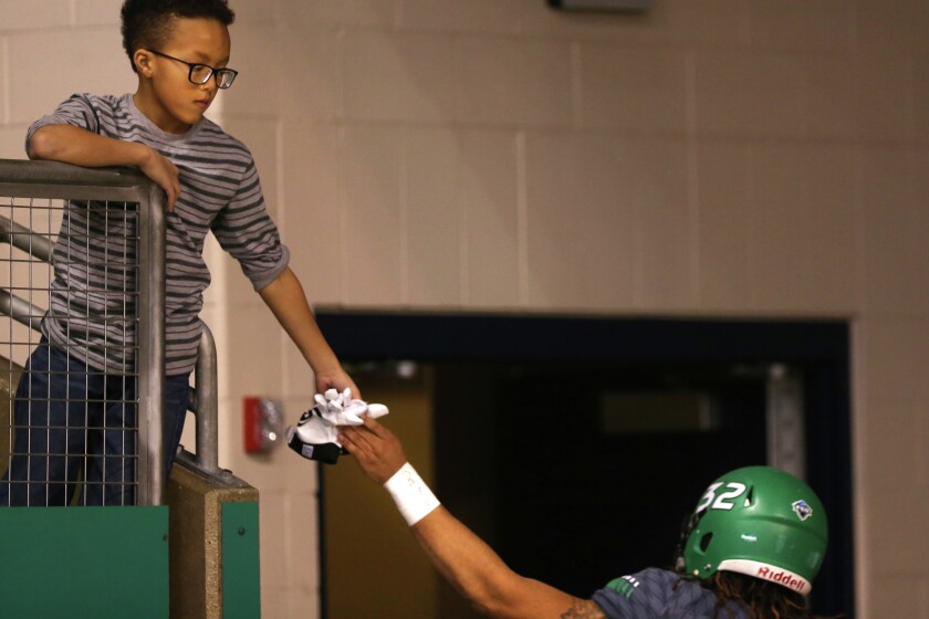 University of North Dakota linebacker Taj Rich (32) high fives Amari Taylor,9 of Grand Forks as he leaves the field, after a 27-24 loss to University of Richmond during the second round of NCAA FCS Quarterfinal at the Alerus Center in Grand Forks, N.D. (Jesse Trelstad/Grand Forks Herald)