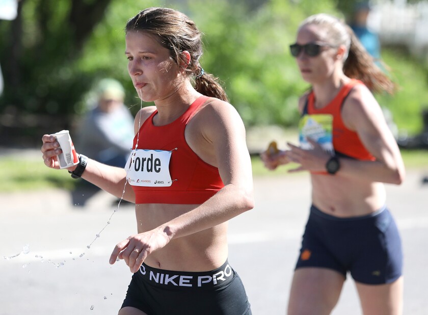 Erin Forde spits out some water as she runs along London Road