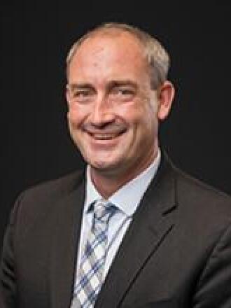 A smiling man in a suit.