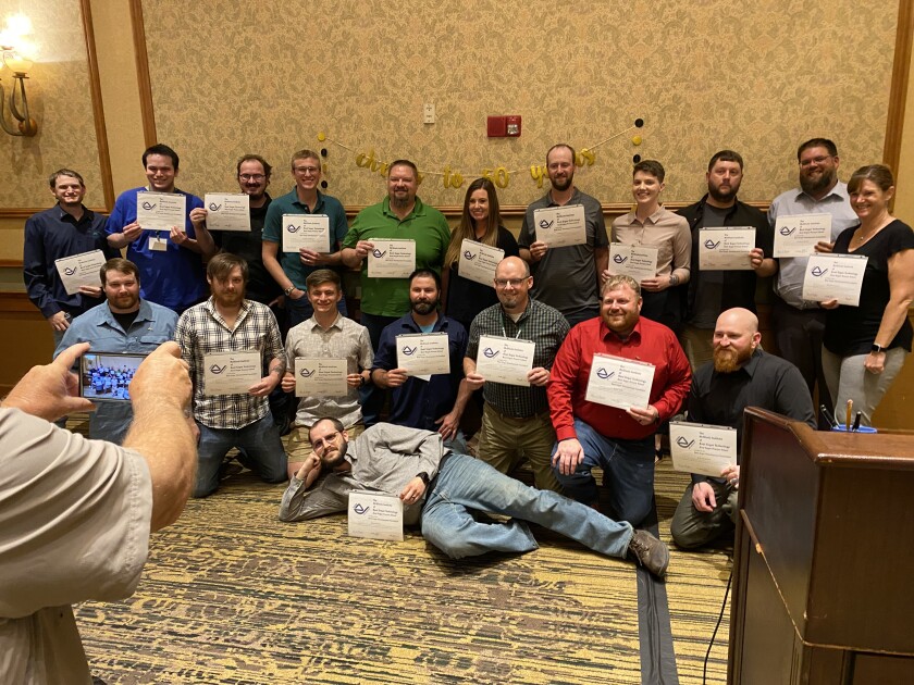 A group of people pose with certificates.