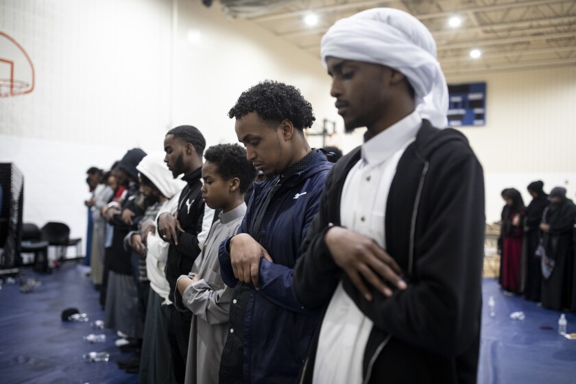 Men pray during fundraiser for Guled Ali Omar