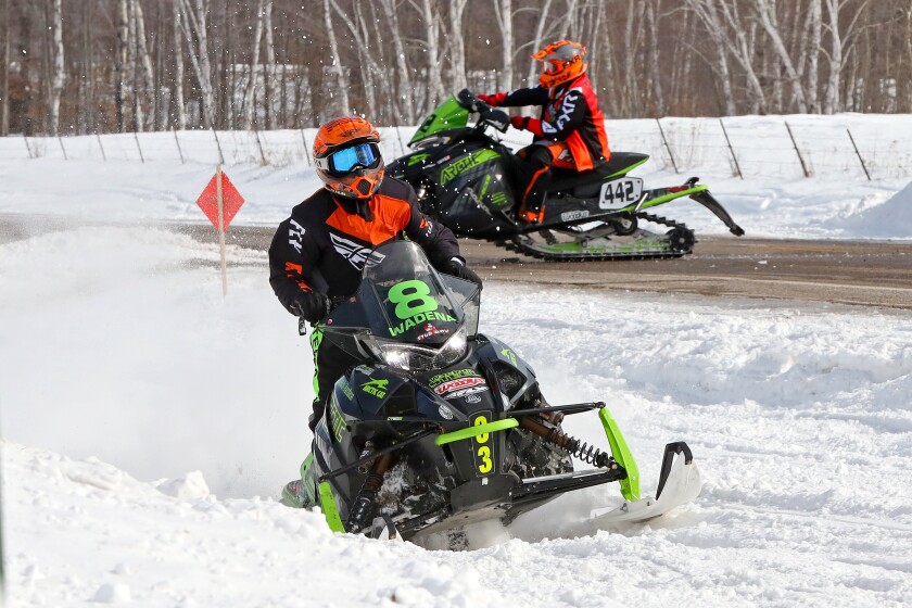 Snowmobilers race.