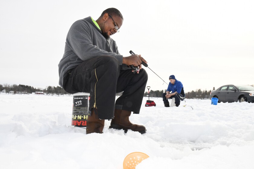Brent Thornton (left) and his friend James Karnowski shed their coats in the 40-degree temperatures Tuesday and fished for panfish on Rice Lake in Brainerd. Steve Kohls / Brainerd Dispatch