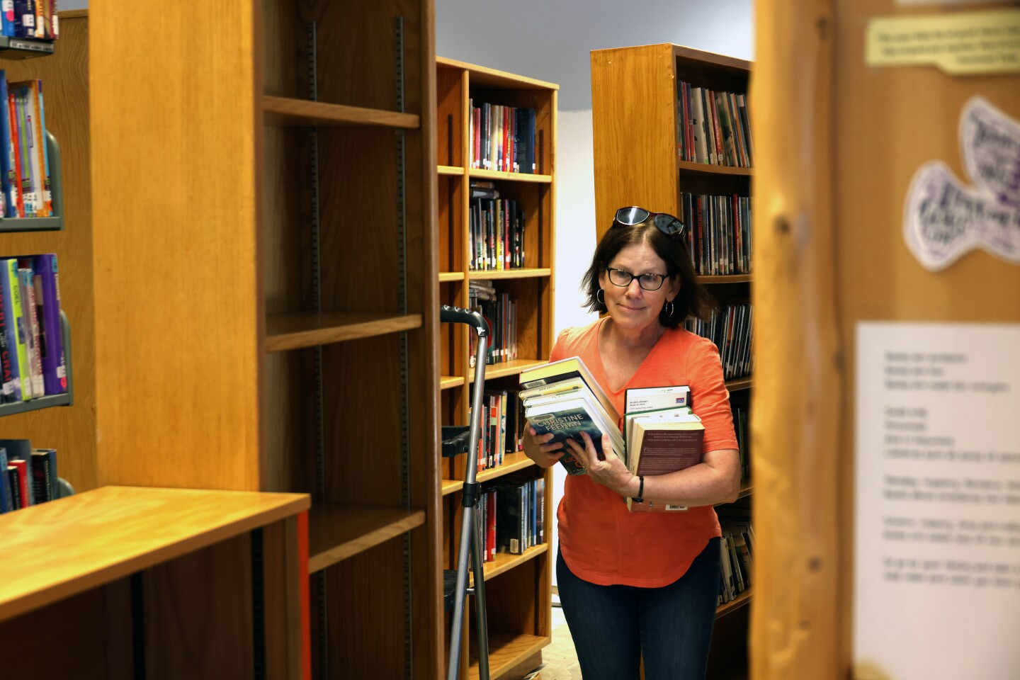 Woman carries books through flood damaged library