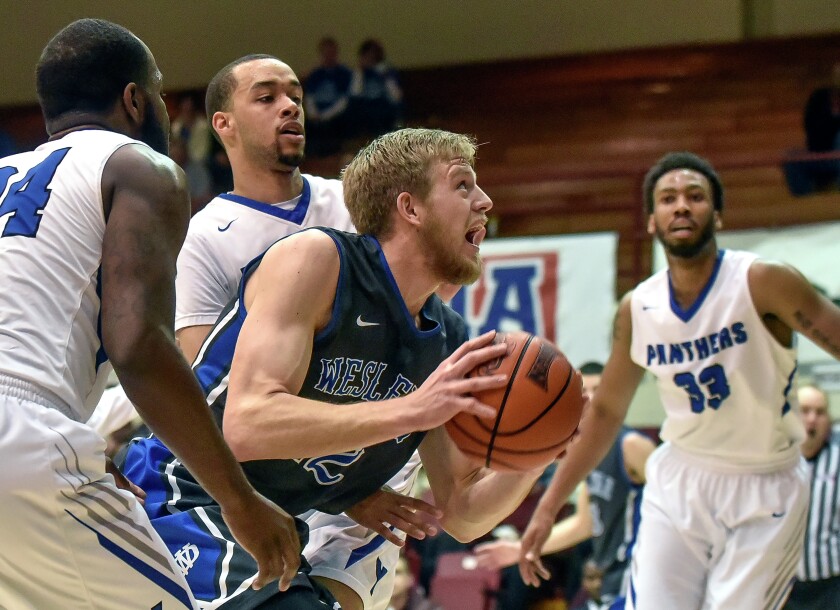 Dakota Wesleyan's Jade Miller (12) fights his way to the basket between York College's Marcus Price (24) and York College's Terrence Cole (4) during the second round of the NAIA Division II men's national tournament on Friday night in the Keeter Gymnasium on the campus of the College of the Ozarks in Point Lookout, MO. (Matt Gade/Republic)