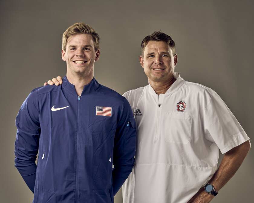 Former University of South Dakota pole vaulter Chris Nilsen poses alongside his coach, Derek Miles, prior to their trip to the 2020 Tokyo Olympics.