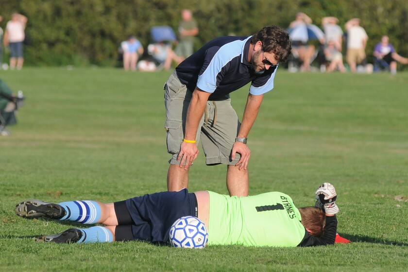Superior trainer Mike Gogolin, top, checks on Spartan goalie Jarret Byrnes (1)