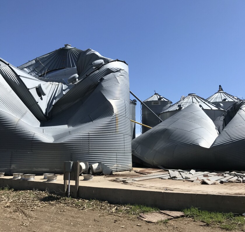 Crumpled, empty grain bins show the power of 100 mph straight winds.