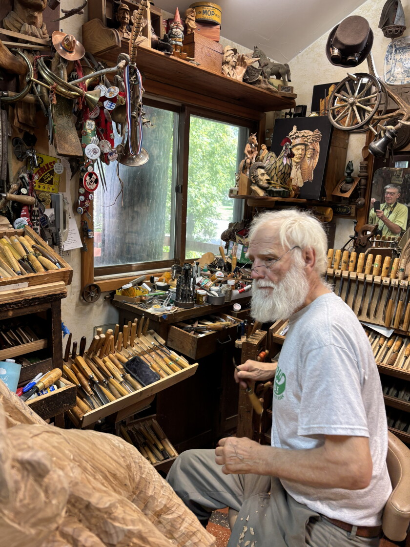 Fred Cogelow looks over a work in his studio on Sept. 9, 2026 as he prepares to grab a woodworking instrument. His collection of carving tools include some of his own design.