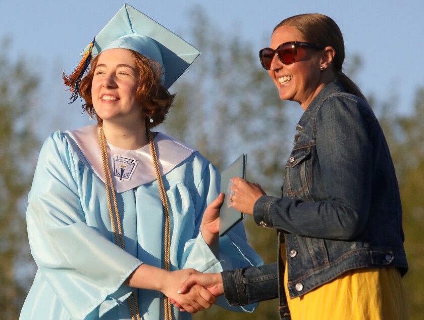 Adelaide Poskozim poses with school board member Brooke Taylor as she receives her diploma