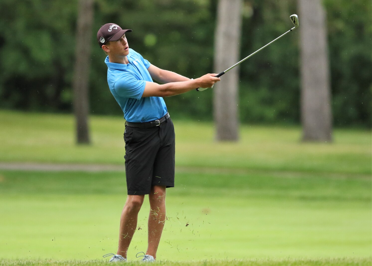 Golfer hits the ball.
