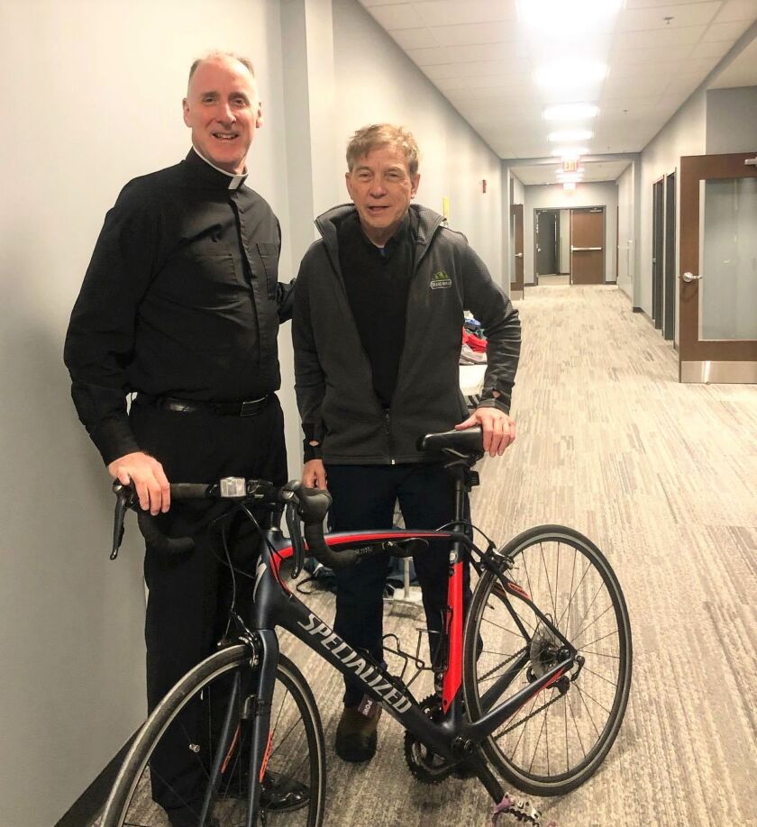 Frs Kinzler and Cheney with donated road bike A.jpg