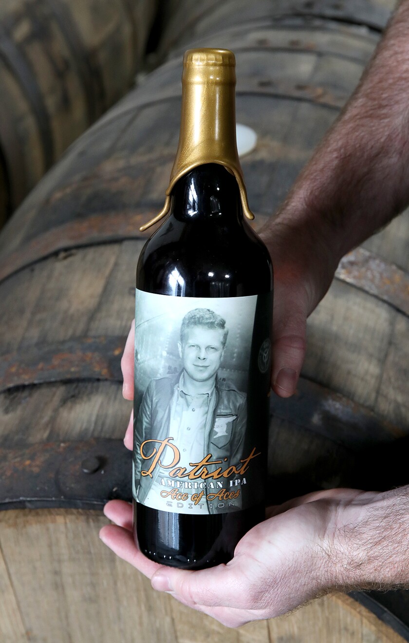 Ben Gipson holds a bottle of Patriot American IPA, Ace of Aces Edition, featuring a photograph of Poplar’s own Richard I. Bong, at the Warrior Brewing Company in Duluth