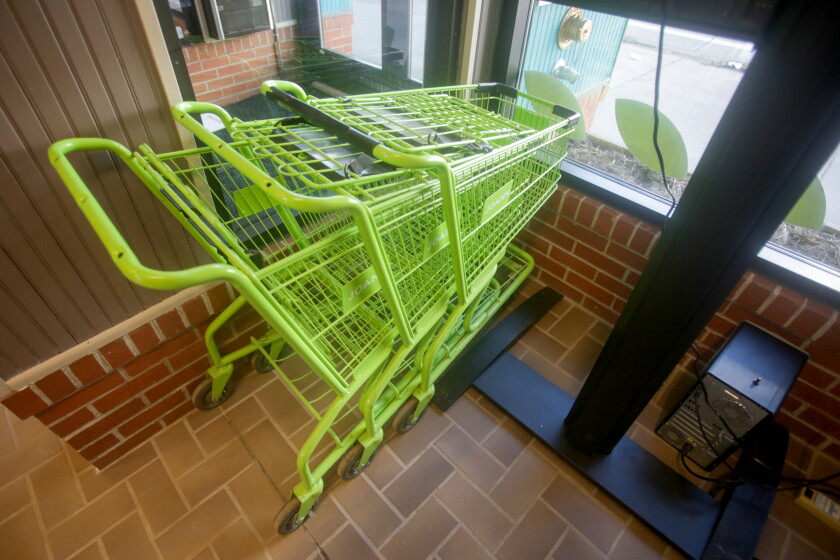 Green grocery carts inside of a store.